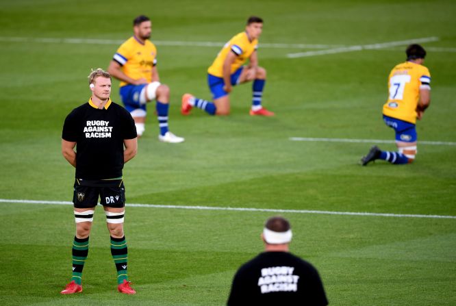 Rugby players from Bath and Northampton show their support before a game in Northampton, England.