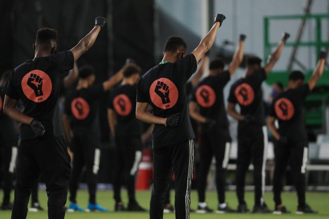 Major League Soccer players participate in a pregame ceremony before the league's restart on July 8.