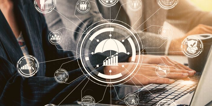 Man and woman typing on laptop with digital icons overlapped representing best risk management software