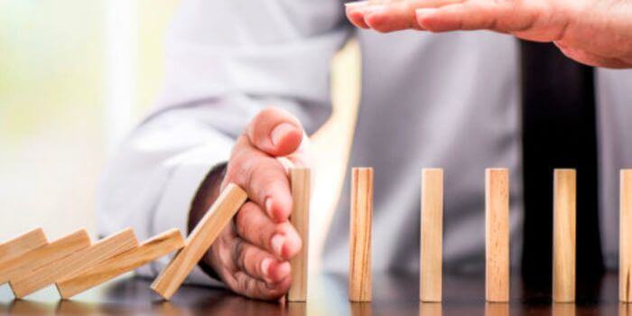 Male hands blocking a row of blocks from dropping representing compensation