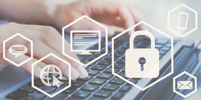 Hands typing on laptop keyboard in background with security icons in the foreground representing enterprise risk management software