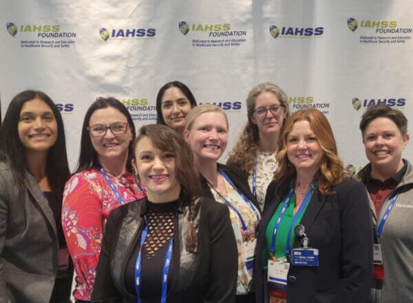 Exploring community & innovation at iahss 2024 3 Group photo of resolver attendees smiling at the iahss 2024 conference in front of a promotional banner.